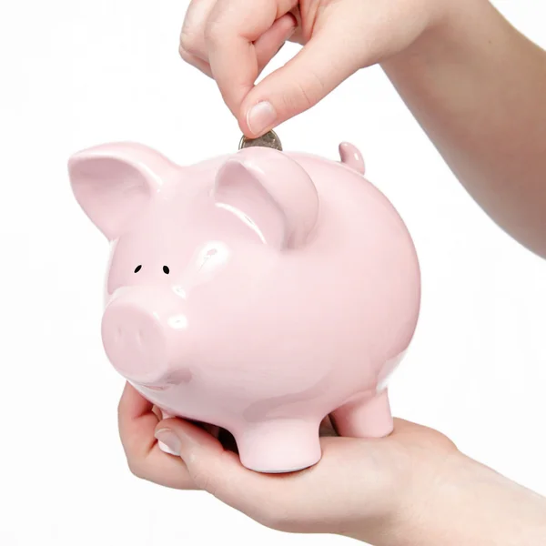 Hand zet munt in piggy bank — Stockfoto