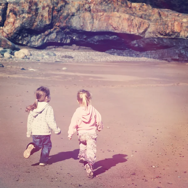 Küçük kızlar sahilde koşmak — Stok fotoğraf