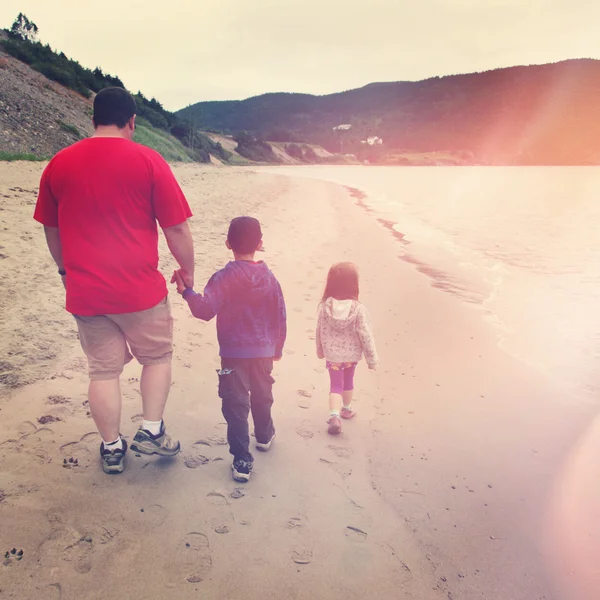 Father and children walking on beach — Stock Photo, Image