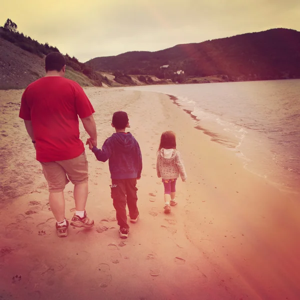 Pai e filhos caminhando na praia — Fotografia de Stock