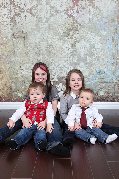 Brothers and sisters sitting on floor — Stock Photo, Image