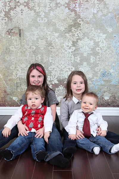 Hermanos y hermanas sentados en el suelo — Foto de Stock