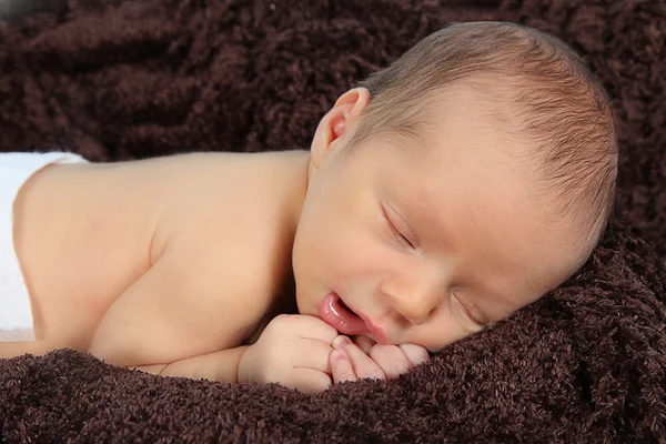 Novorozené dítě spí na hnědou dekou — Stock fotografie