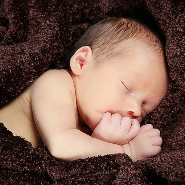 Newborn baby sleeping on brown blanket — Stock Photo, Image