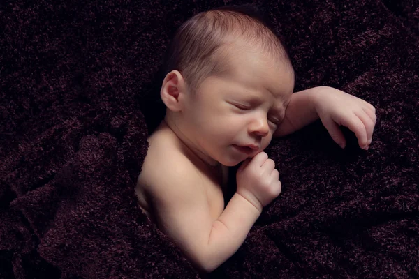 Novorozené dítě spí na hnědou dekou — Stock fotografie