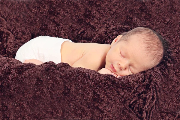 Newborn baby sleeping on brown blanket — Stock Photo, Image