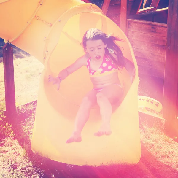 Маленькая девочка играет на детской площадке — стоковое фото