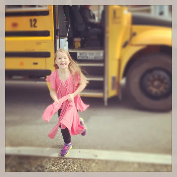 Menina saindo do ônibus escolar — Fotografia de Stock