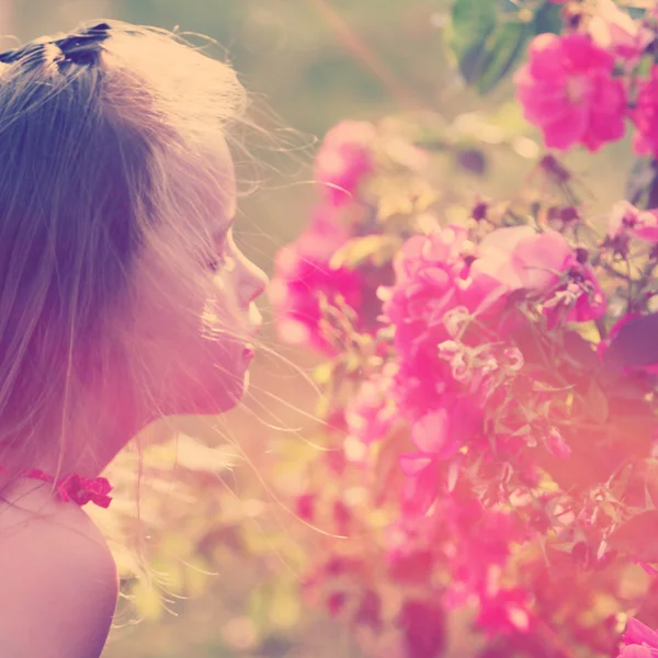 Kleines Mädchen, das Blumen riecht — Stockfoto