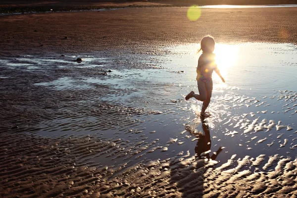 Mädchen läuft auf Pfützen — Stockfoto