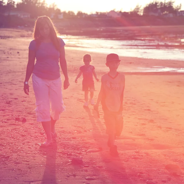 Mor och barn gå på stranden — Stockfoto