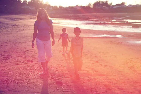 Мати і діти, що гуляють на пляжі — стокове фото