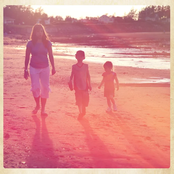 Mor och barn gå på stranden — Stockfoto