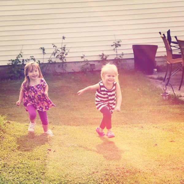 Pequenas meninas correndo na grama — Fotografia de Stock
