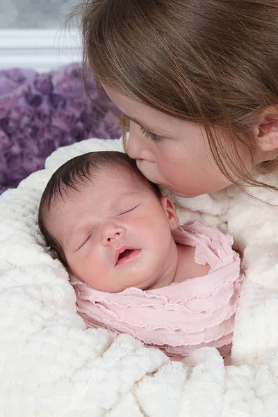Kleine meisje kussen baby — Stockfoto