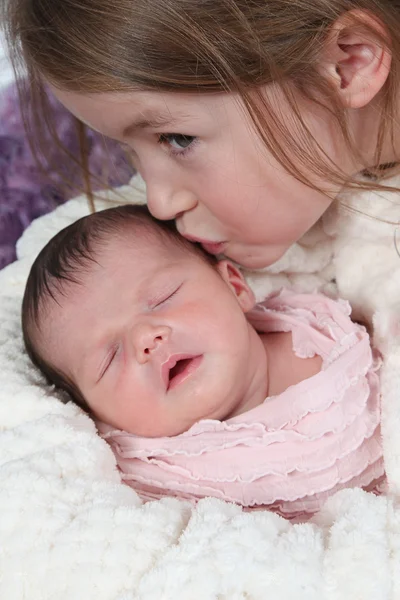 Kis lány a csókolózás baba — Stock Fotó