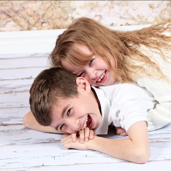 Fratellino e sorella sdraiati sul pavimento — Foto Stock