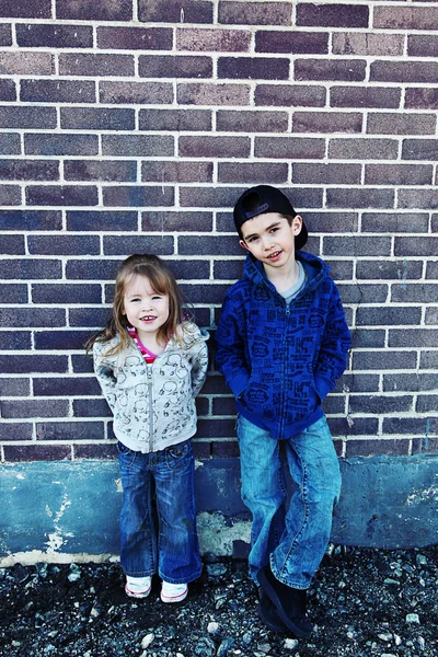 Brother and Sister on brick background — Stock Photo, Image