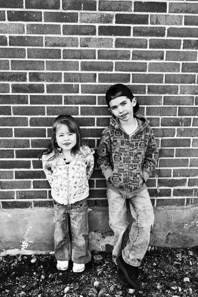 Little brother and Sister on brick background — Stock Photo, Image