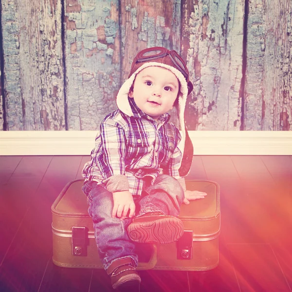 Carino piccolo bambino seduto sulla valigia — Foto Stock