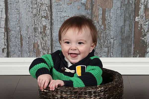 Malý chlapec s úsměvem v košíku — Stock fotografie