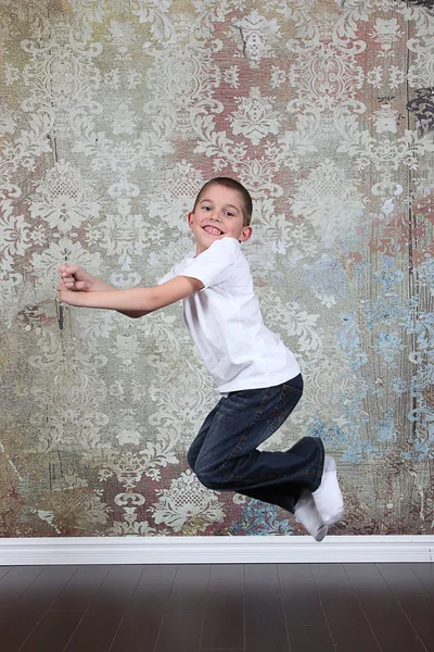 Little boy jumping in old empty room — Stock Photo, Image