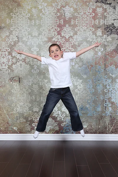 Menino saltando no velho quarto vazio — Fotografia de Stock