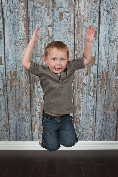 Little boy jumping in old empty room — Stock Photo, Image