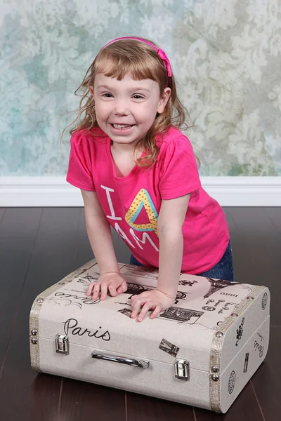 Μικρό κορίτσι που κάθεται σε βαλίτσα — Φωτογραφία Αρχείου