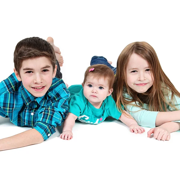 Little Boy y sus hermanas tumbados en el suelo — Foto de Stock