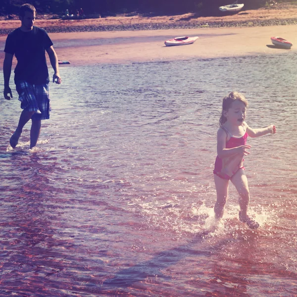 Pappa leker med barnen på stranden — Stockfoto