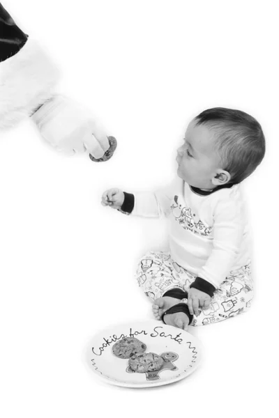 Baby boy taking cookies from Santa — Stock Photo, Image