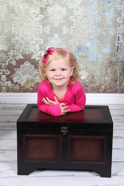Little Girl leaning on vintage chest — Stock Photo, Image