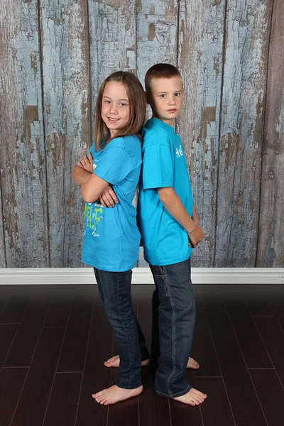 Brother and Sister stand back to back — Stock Photo, Image