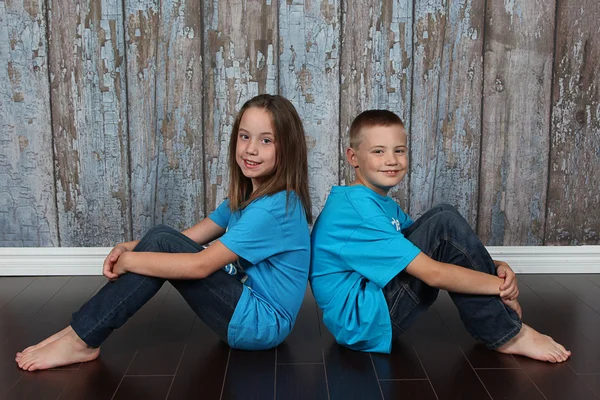 Fratello e sorella seduti dietro — Foto Stock