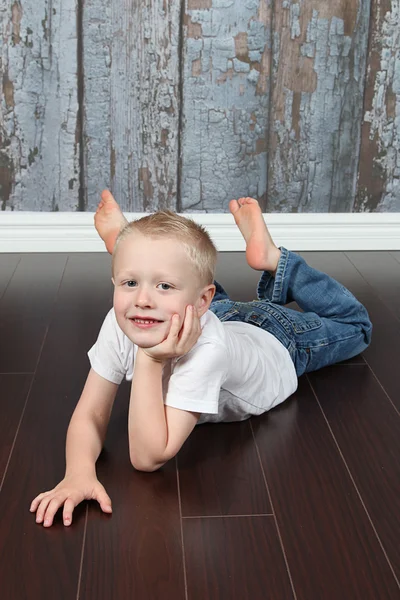 Liten pojke liggande på golvet — Stockfoto