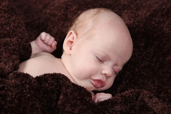 Pasgeboren baby slapen op bruine deken — Stockfoto