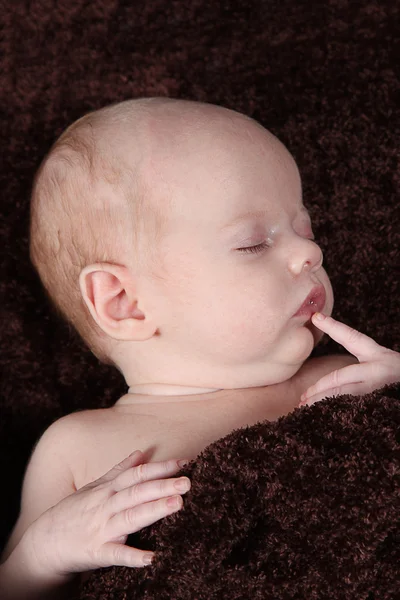 Новорожденный ребенок спит на коричневом одеяле — стоковое фото