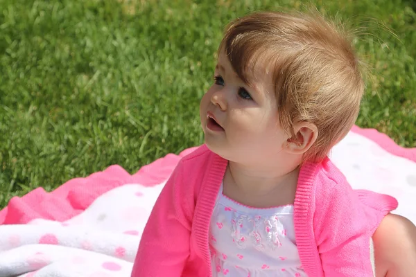 Little girl sitting on blanket outdoors — Stock Photo, Image