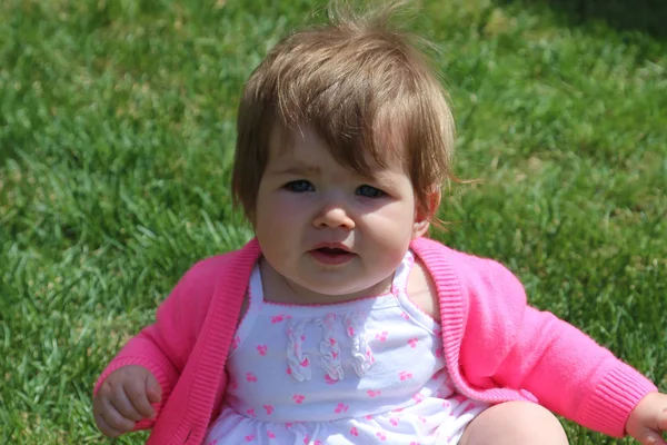 Little girl sitting on grass — Stock Photo, Image