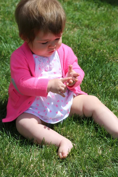 Kis lány ül a fűben — Stock Fotó