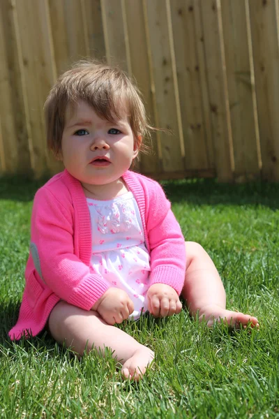 Little girl sitting on grass — Stock Photo, Image