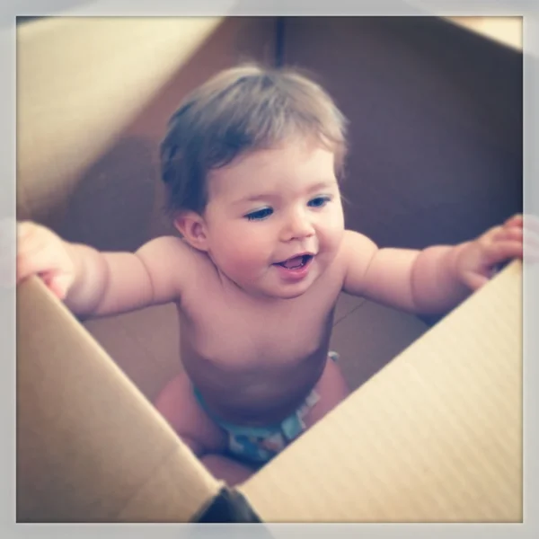 Pequena menina na caixa de transporte — Fotografia de Stock