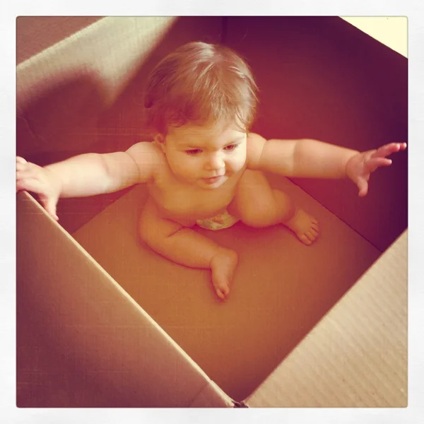 Маленька дівчинка в коробці для перевезення — стокове фото