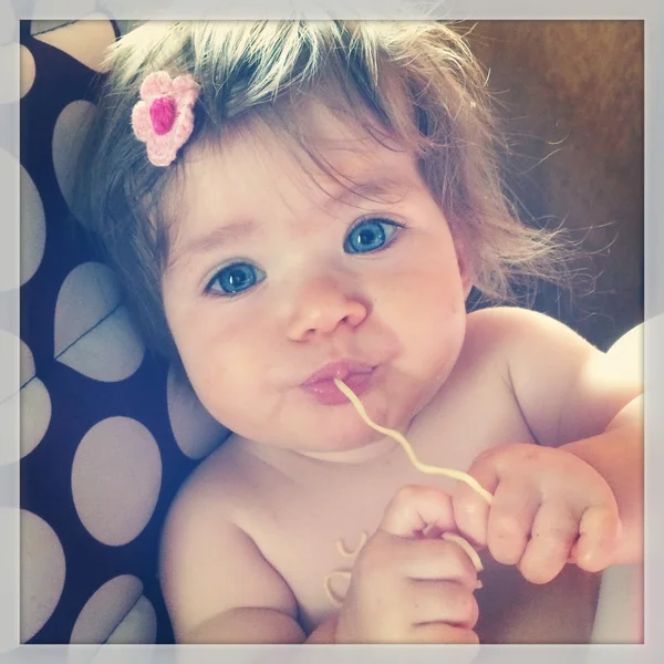 Dulce bebé comiendo fideos —  Fotos de Stock