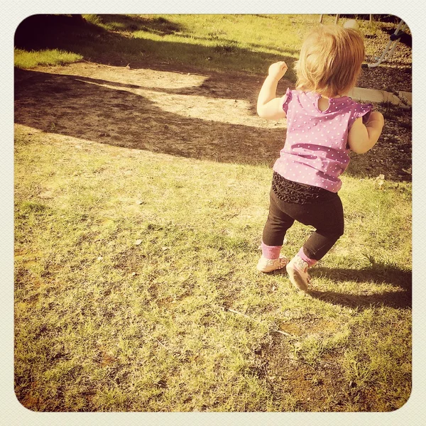 Petite fille courir dans l'herbe — Photo