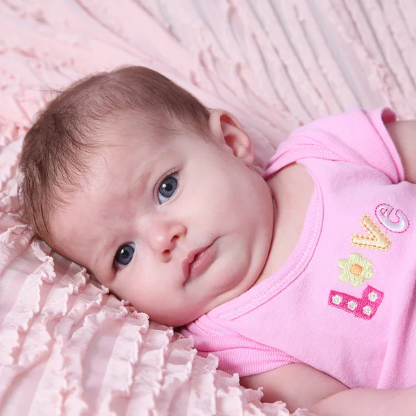 Новонароджена дитина лежить на рожевій ковдрі — стокове фото