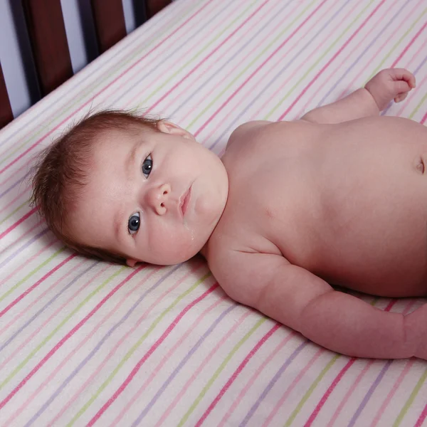 Nyfödd baby flicka i spjälsäng — Stockfoto