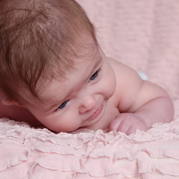 Новорожденный ребенок лежит на розовом одеяле — стоковое фото