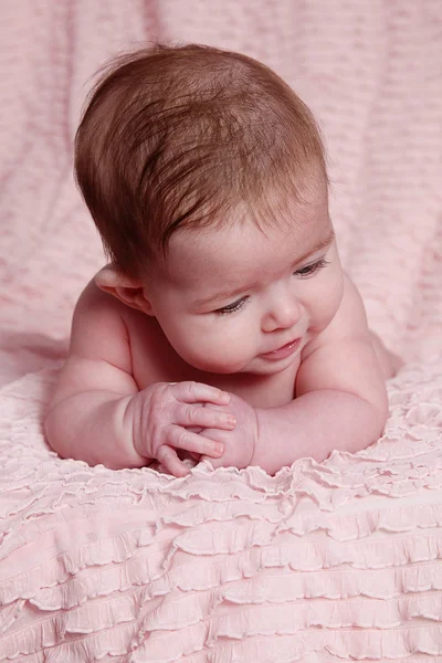 Новорожденный ребенок лежит на розовом одеяле — стоковое фото
